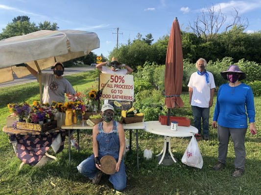 Volunteers run a produce stand that donates proceeds to a local food bank.