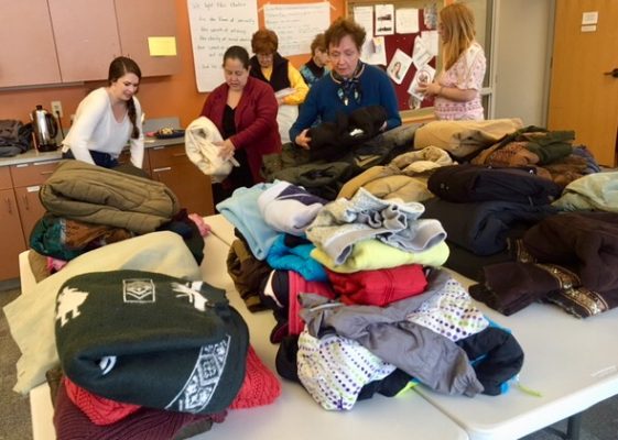 Volunteers sort donated clothing into piles.