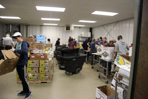 Teens and adults sort food donations at a local food bank.