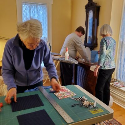 Several people work on a quilting project.
